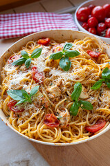 Delicious homemade pasta dish with spaghetti alla caprese with red pesto, mozzarella cheese, parmesan cheese and pine nuts