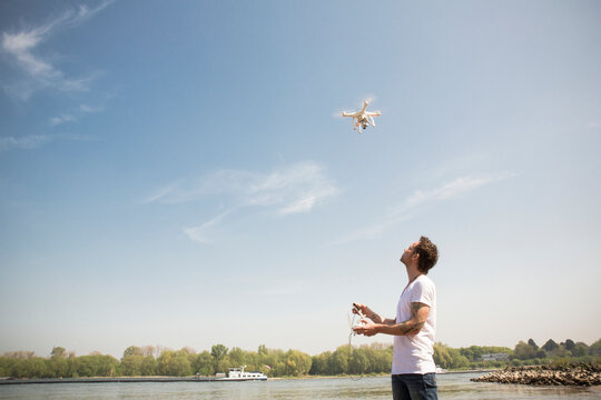 Man flying drone at a river