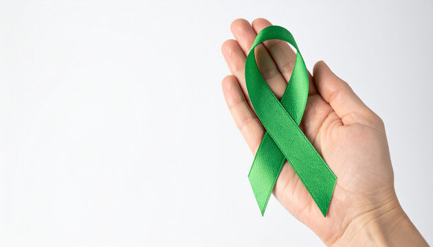 Hand holding green awareness ribbon. Mental health, kidney disease, cerebral palsy