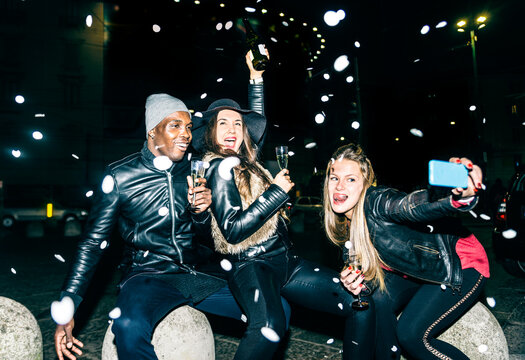 Enthusiastic friends having a party outdoors at night