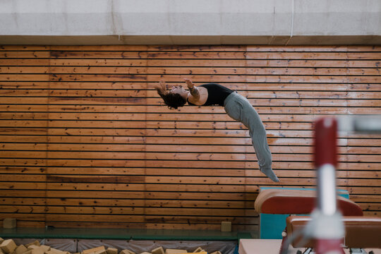 Gymnast exercising at vaulting table in gym
