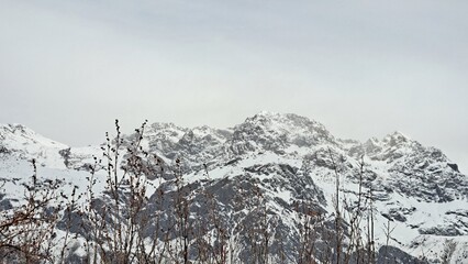 A rugged mountain landscape with steep, rocky peaks covered in snow.