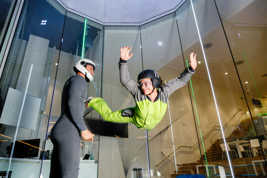 Instructor guiding man at indoor skydiving center
