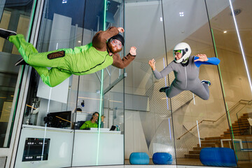 Instructor with man flying at indoor skydiving center