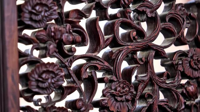 Intricate wood carvings, dark reddish-brown tones, floral and scrollwork patterns, detailed close-up