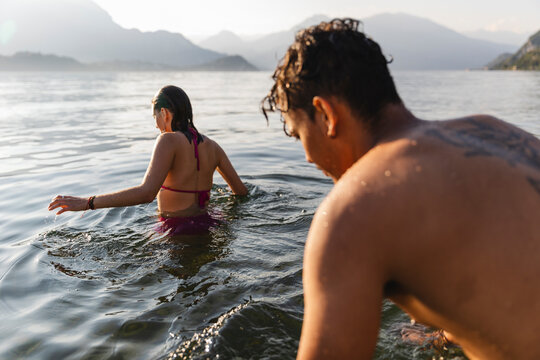 Young couple entering a lake