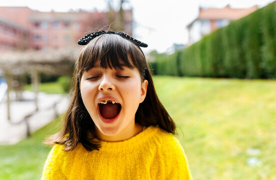 Portrait of a girl with braces on her teeth outdoors