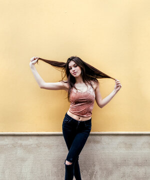 Portrait of a beautiful brunette woman in front of a wall