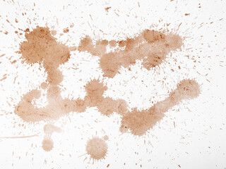 Light brown coffee splatters and streaks on a white background.