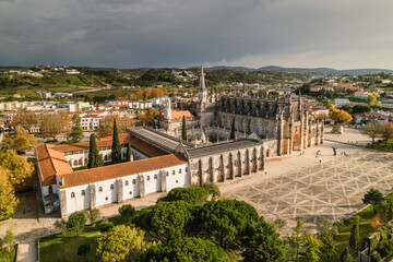 Obraz premium Batalha Monastery in Portugal – aerial drone view of Gothic and Manueline masterpiece, ornate stonework and arches. UNESCO site, perfect for culture, travel, architecture and heritage photography.