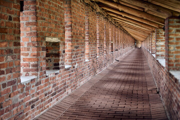 Long brick corridor of Nizhny Novgorod kremlin, showcasing detailed masonry and repetitive arches. Soft, ambient lighting creates warm and historical atmosphere, with perspective drawing into distance