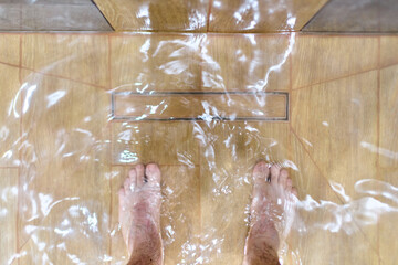 Overhead view of standing water on shower floor due to clogged drain. Tiled surface with visible...