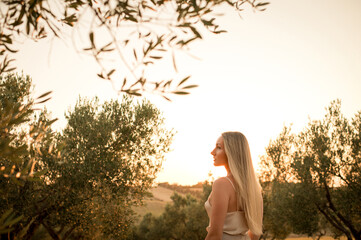 Young woman with long blond hair enjoying sunset outdoors, symbol of healthy hair, natural beauty,...