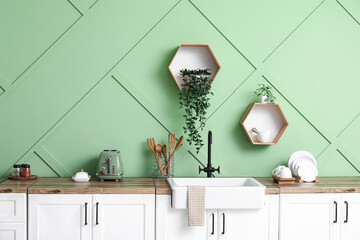 Interior of modern kitchen with stylish counter, sink and kitchenware, closeup