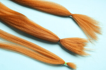Red hair strands for donation on blue background