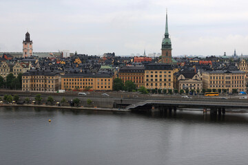 Obraz premium Photo with a view of St. Gertrude's Church (Tyska kyrkan), the historic buildings of the old town (Gamla Stan) and the waterfront against a cloudy sky in central Stockholm, Sweden