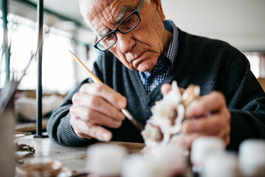 Senior man decorating ceramic in his spare time