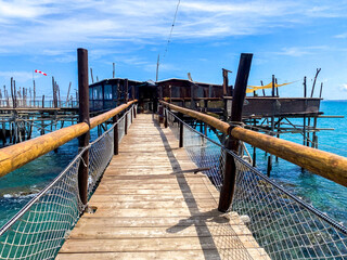 Wooden pier leading to a trabocco, a traditional fishing platform on the Adriatic coast of Abruzzo,...