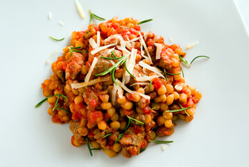 Fregula con pomodoro e salsiccia, pasta sarda, cibo italiano 