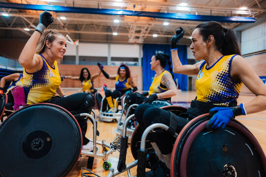 Happy disabled rugby players winning match at sports court