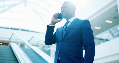 Successful businessman in blue suit smiling while talking on phone in modern building - Powered by Adobe