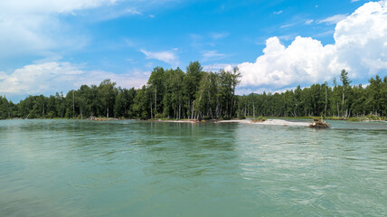 A peaceful scene of a river with a green island, lush woods, and clear sky, evokes harmony with nature in a serene landscape.
