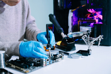 Computer technician in gloves safely repairing desktop hardware. Closeup view of hands fixing GPU...