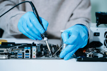 Computer technician in gloves safely repairing desktop hardware. Closeup view of hands fixing GPU...