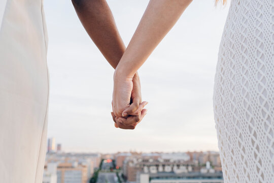 Young women holding hands of each other during sunset - Powered by Adobe