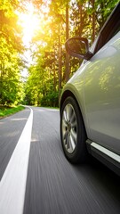 Silver car driving on a sunny forest road