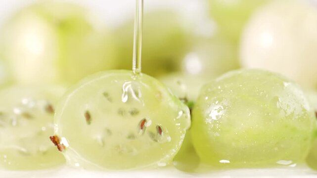 Close-up shot of a halved gooseberry with water flowing over it, emphasizing the juicy, fresh texture of the fruit. Perfect for content on healthy eating, fresh produce, and natural beauty