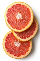 Slices of fresh red grapefruit arranged on a white background