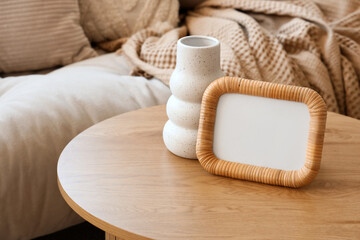 Vase and frame on coffee table in living room. Closeup