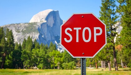 Red Stop Sign in Yosemite National Park with Half Dome Mountain Background.