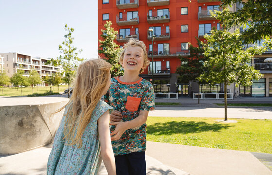 Happy brother playing with sister on playground