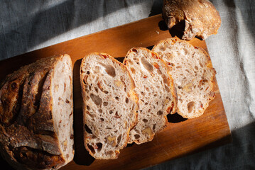 cranberry walnuts sourdough bread sliced placed on wooden cutting board.