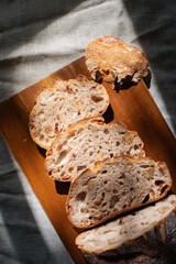 cranberry walnuts sourdough bread sliced placed on wooden cutting board.