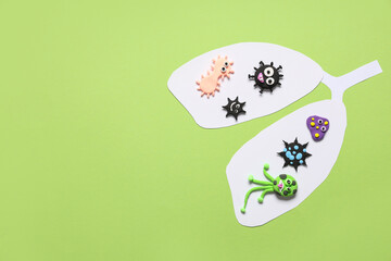 Paper lungs with plasticine viruses on green background