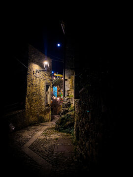 Moonlit cobblestone alley winding through the historic village of Pretoro in Abruzzo, Italy, creating a charming nocturnal scene