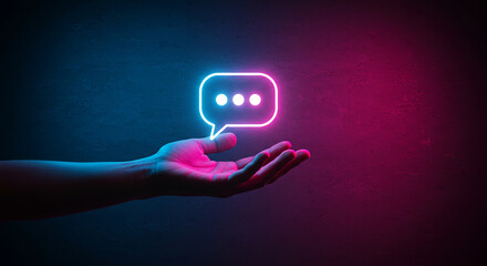 Hand Holding Neon Message Bubble Icon in Dark Futuristic Space