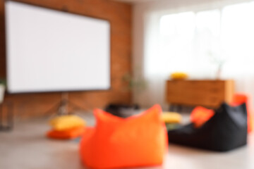 Blurred view of room with beanbags and projector screen