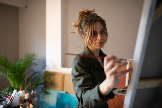 Young woman painting in her atelier