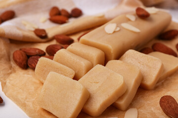 Baking paper with tasty marzipan and almond nuts, closeup
