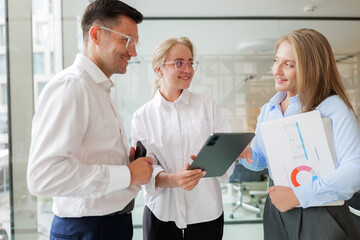 Team members engage in a lively discussion while reviewing a digital presentation in a modern office space filled with creativity