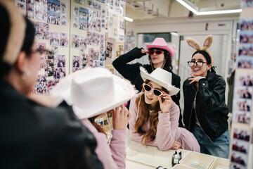 Friends wearing costumes having fun in urban photo booth studio