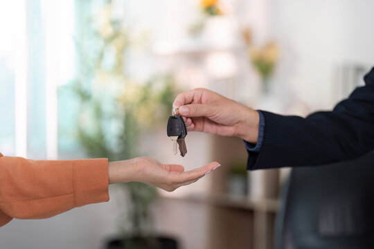 Key Handover. Real estate agent giving keys to a new homeowner in a professional setting.