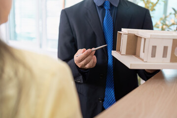 Real Estate Consultation. Agent presenting property model to client.