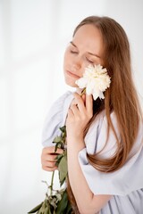 Naklejka premium a young beautiful girl with peony flowers on a white isolated background, space and room for text