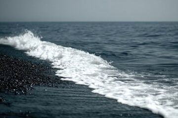 Fototapeta premium Foamy wave crests on dark water's edge