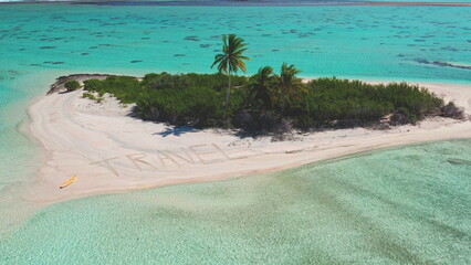 Crystal clear turquoise waters surround a small sandy island featuring lush greenery and a palm tree. The word 'TRAVEL' is written in the sand, inviting exploration and adventure.